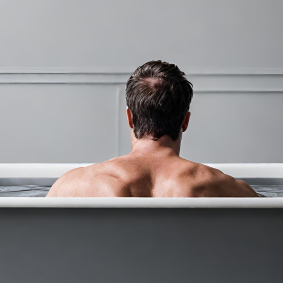 Man having a cold plunge on a gray tub